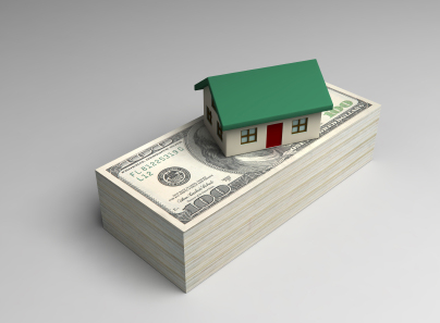 Stack of money with miniature house on top